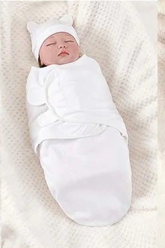 Baby settled into a white Swaddle Buddy with matching hat